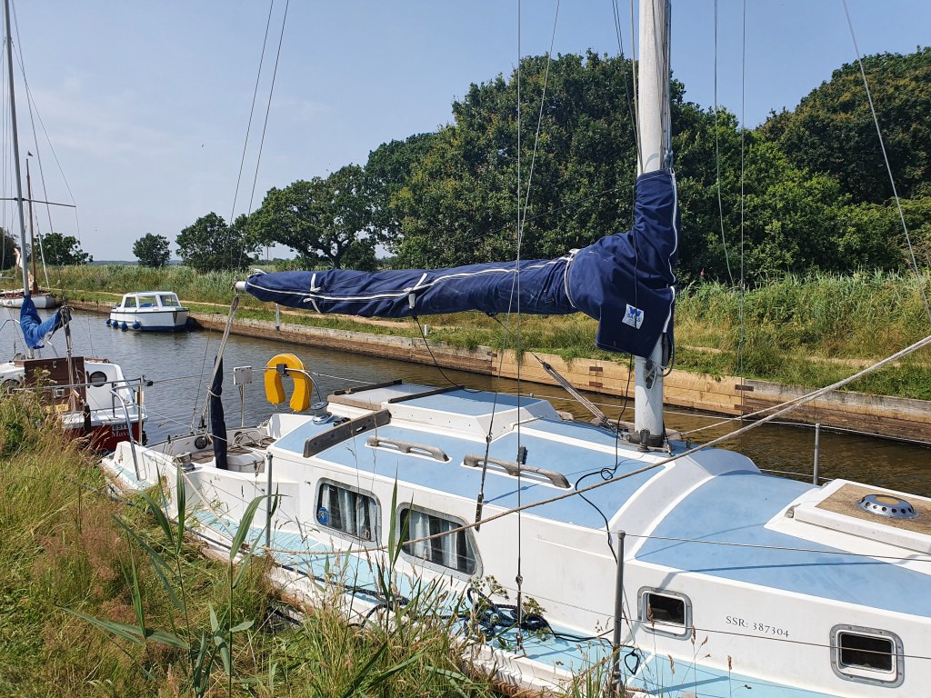 Westerly Centaur "Rosie Free" on her mooring on the Norfolk Broads amongst the tall grass and reeds.